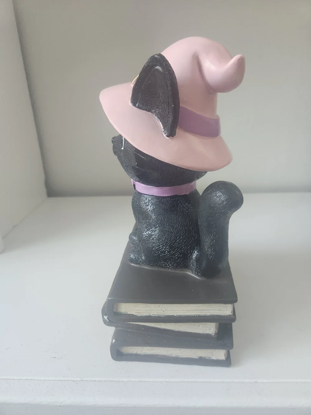 Black Cat Wearing Pink Witches Hat Sitting On Top Of Books Figuring